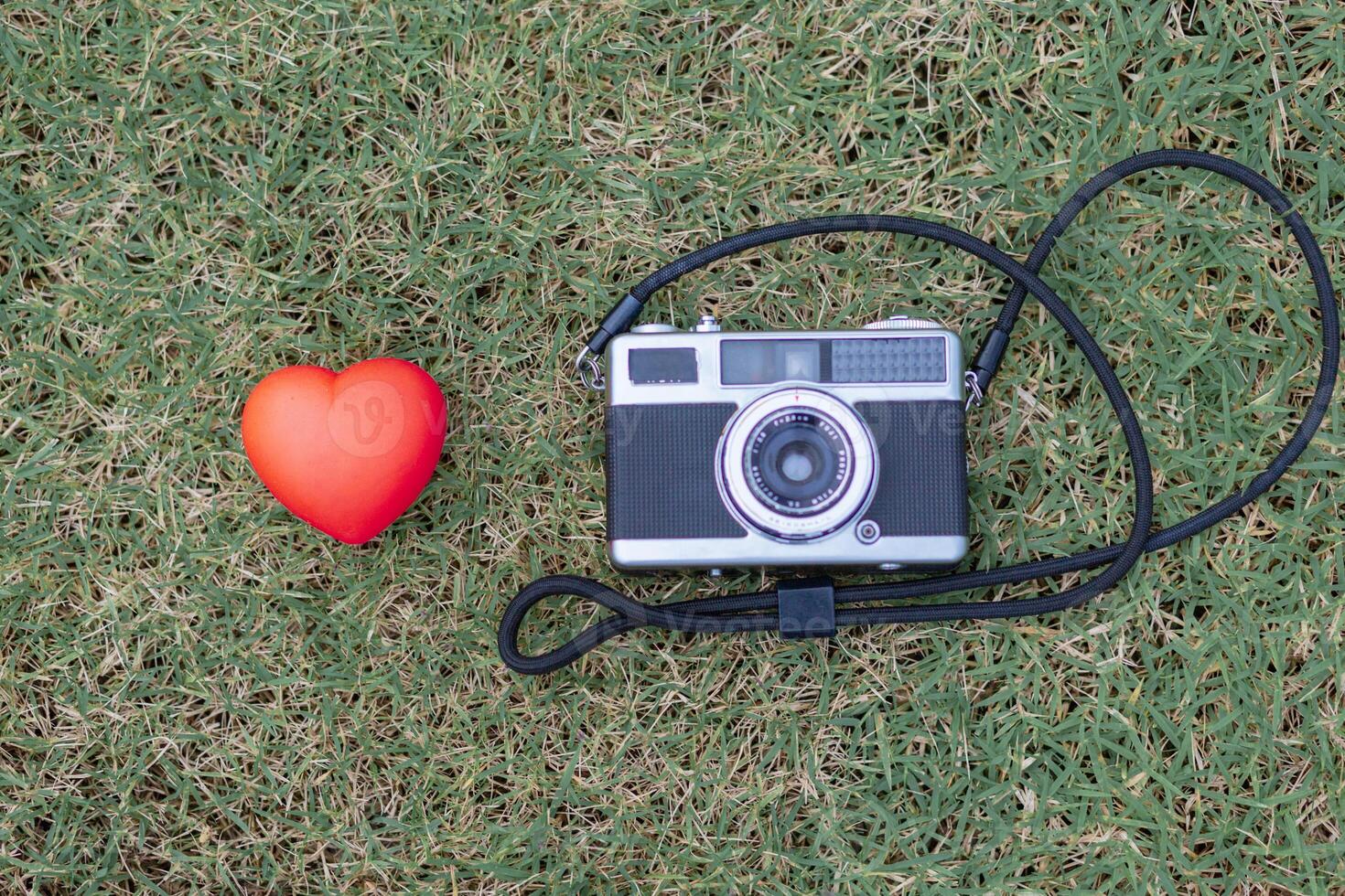 Film cameras and red heart symbol are placed on photographer desk to symbolize the love of photography and the unique tone film camera. Some photographers are still in love with film cameras. photo