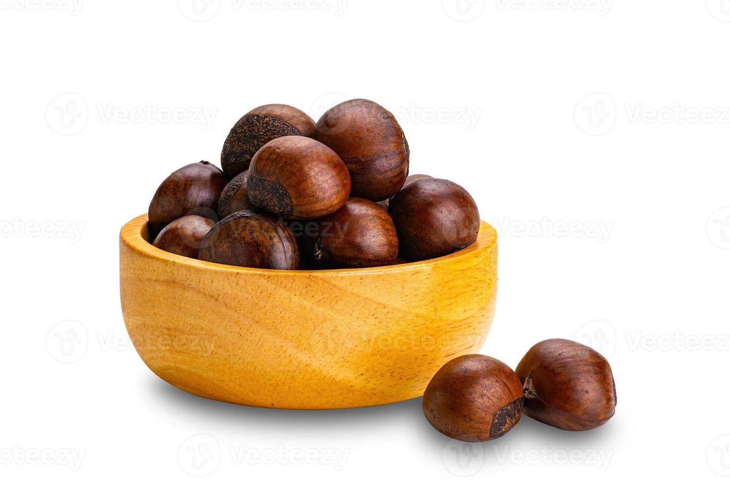 Side view pile of chestnuts in wooden bowl and on the floor isolated on white background. photo