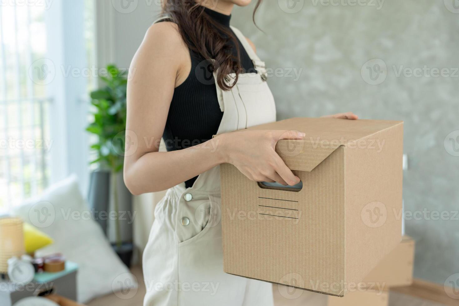 relocation. Woman hold carton box contain equipment for new condominium, inside the room was a cardboard box containing personal belongings and furniture photo