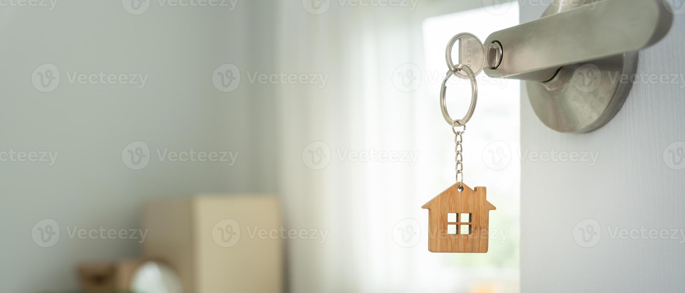 relocation. The key was inserted into the door of the new house, inside the room was a cardboard box containing personal belongings and furniture. move in the apartment, banner photo
