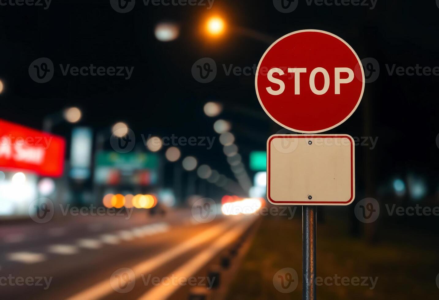 A red Stop sign and blank white sign, roadside warning sign, exhibiting a blurred bokeh effect of road photo