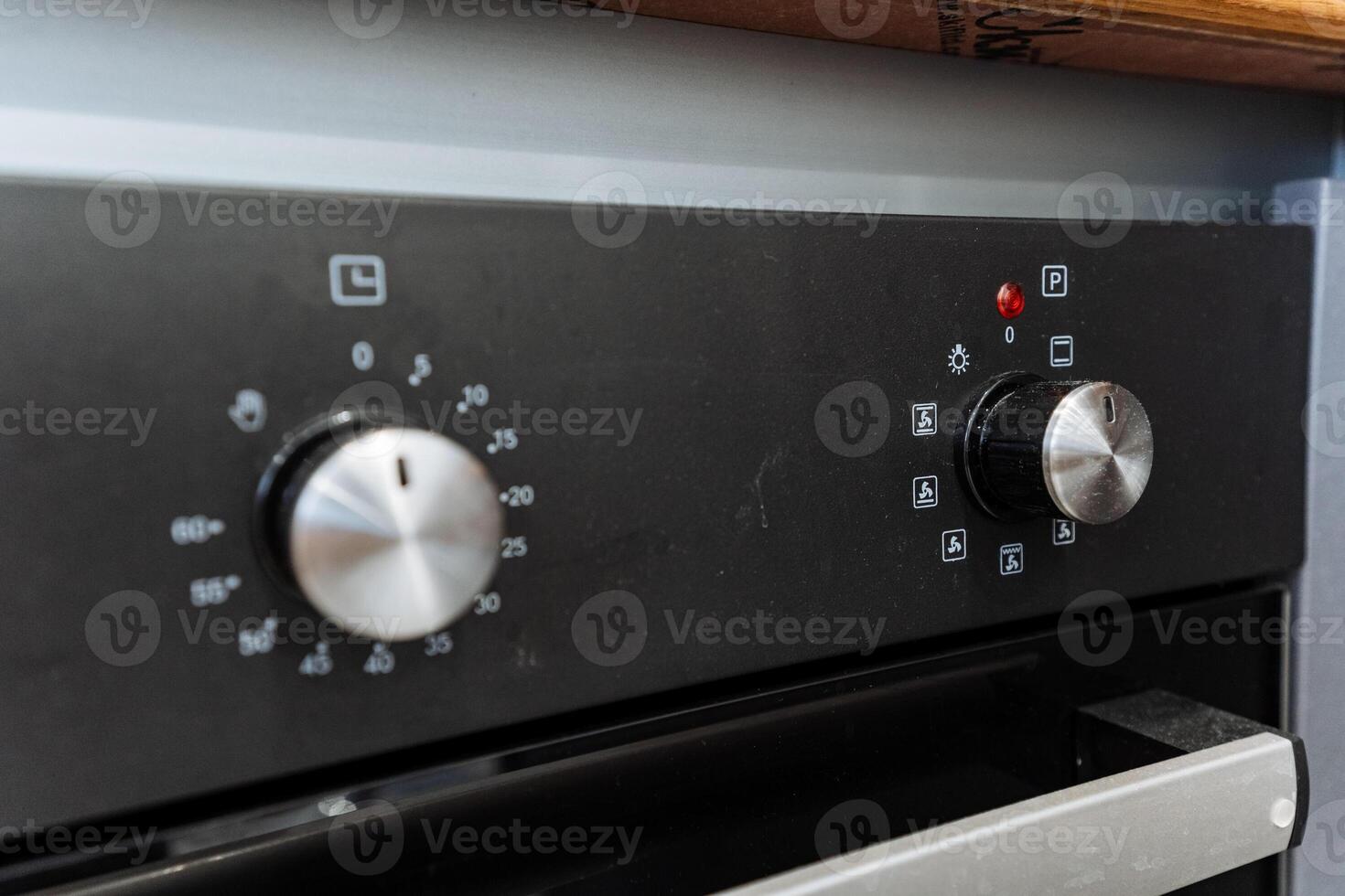 A close up of a black oven with two knobs photo