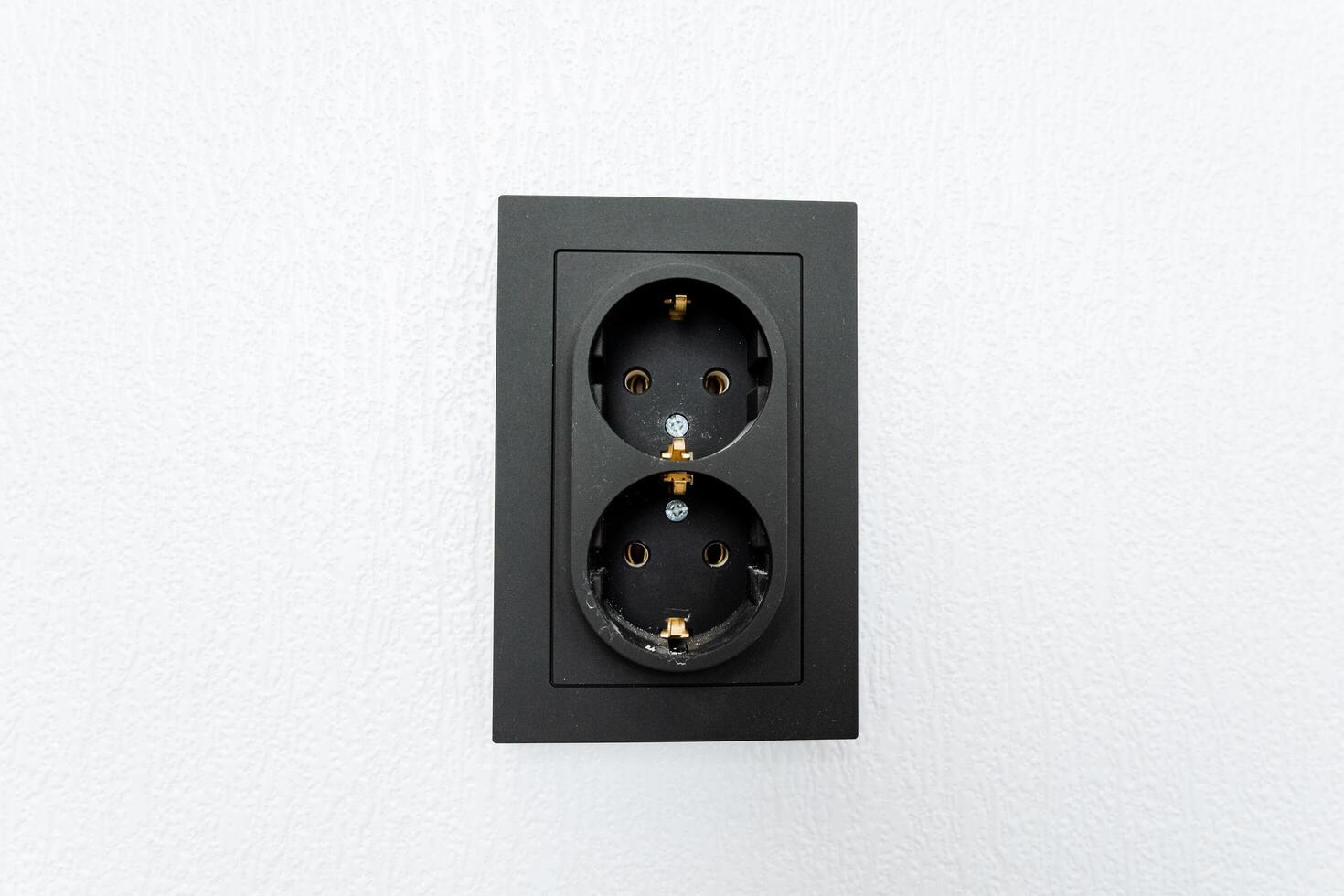 A black electrical outlet with two plugs on it photo