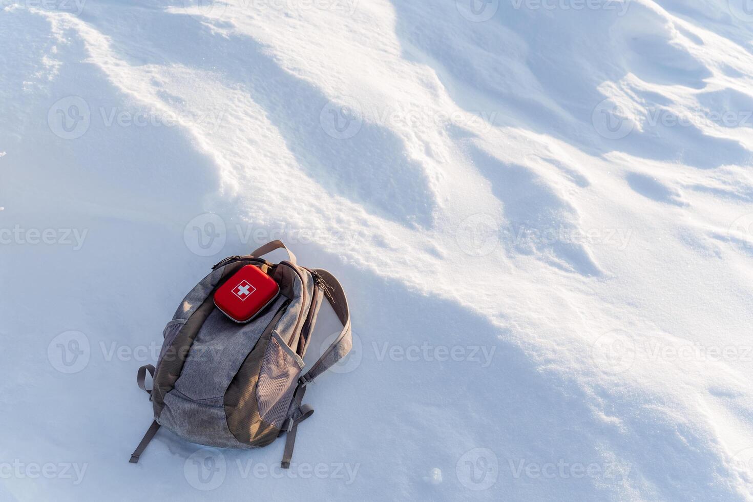 A backpack is sitting on top of a snow covered hill photo