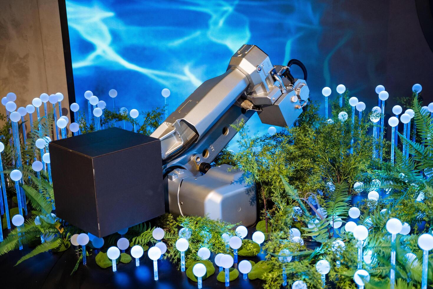 A robot is sitting on a table with plants photo