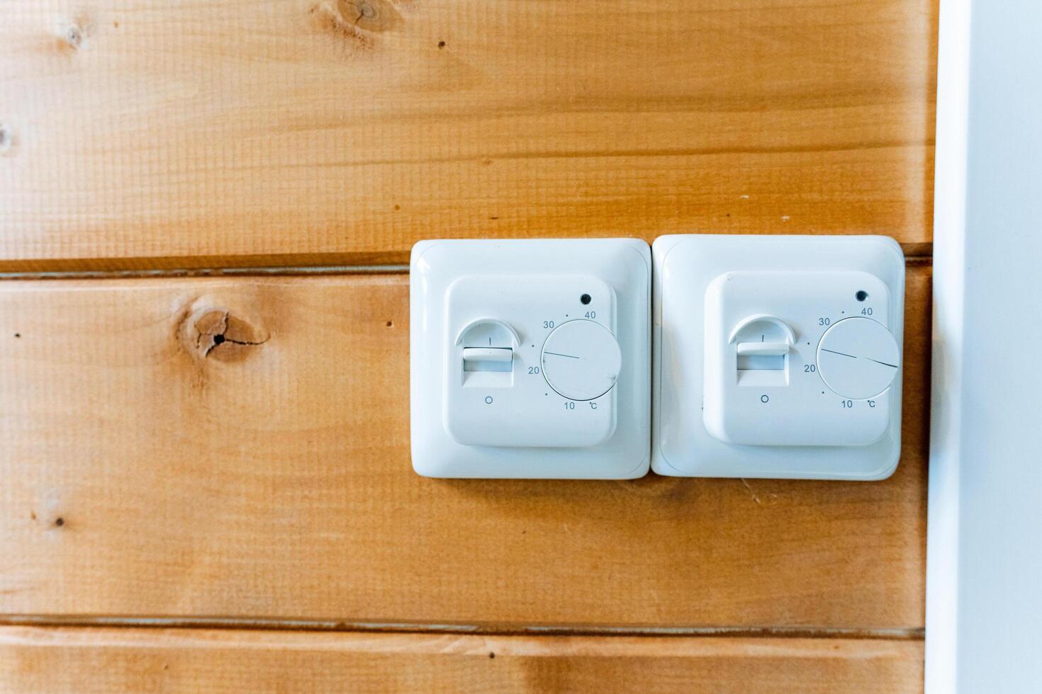 Two white switches on a wooden wall photo