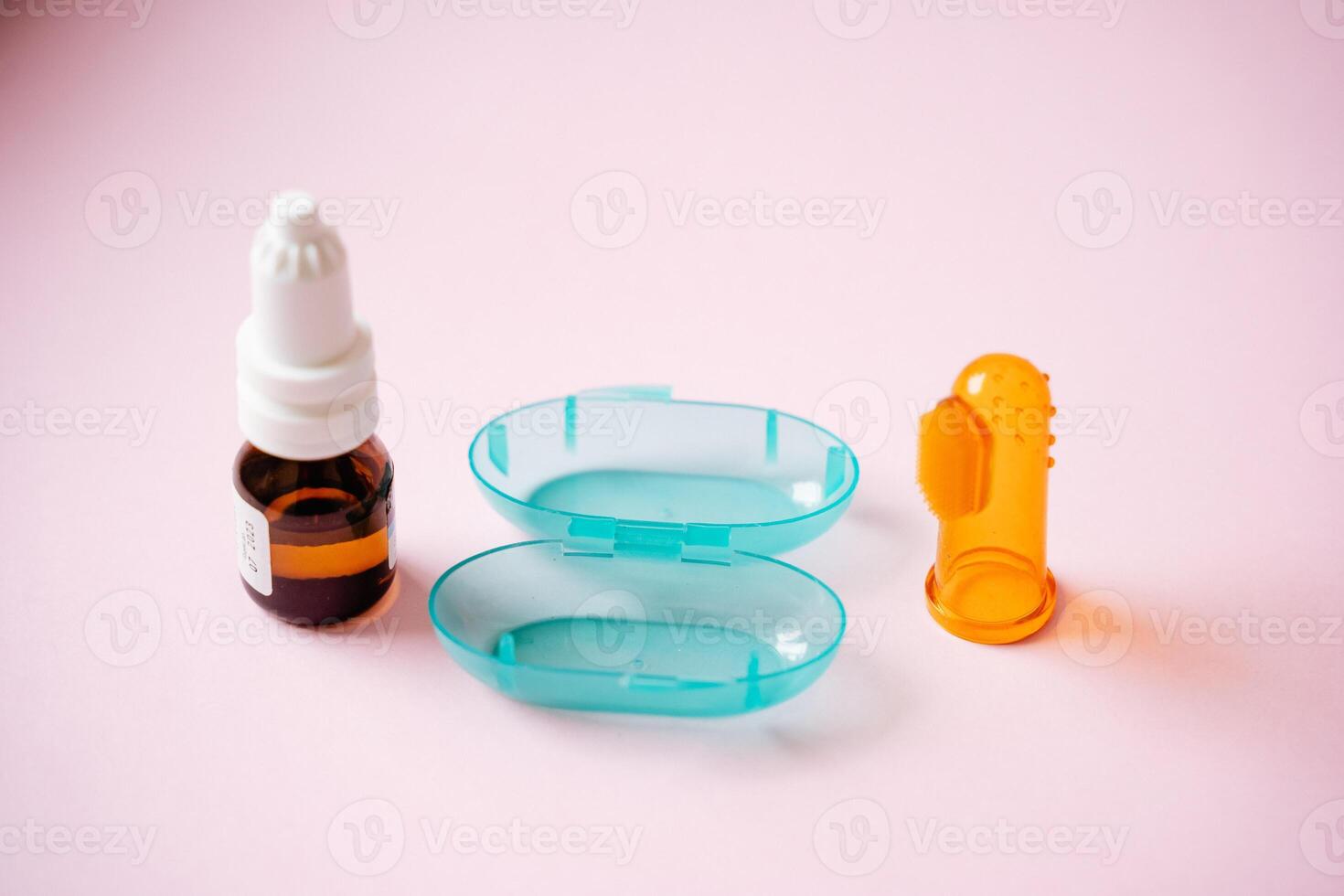 In close proximity to a pair of contact lenses, there is a bottle filled with eye drops, representing essential items for personal care and eye health, often found in the office or at home photo