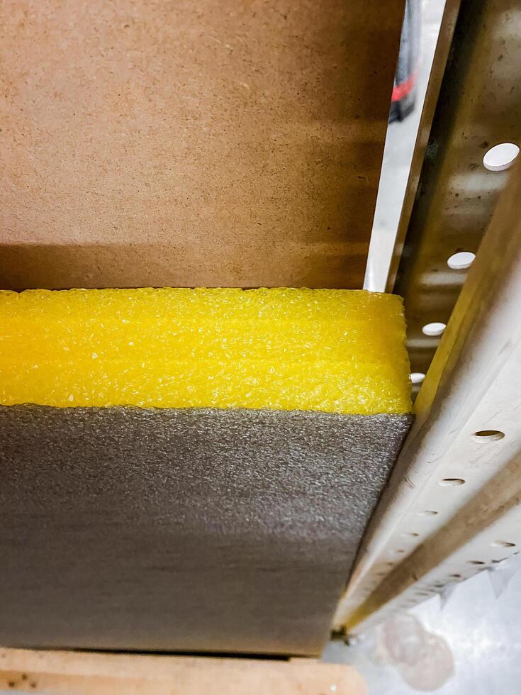 A vibrant, eyecatching yellow foam rests gently on a robust and sturdy metal piece, creating a captivating and fascinating contrast between the two distinct and unique materials photo