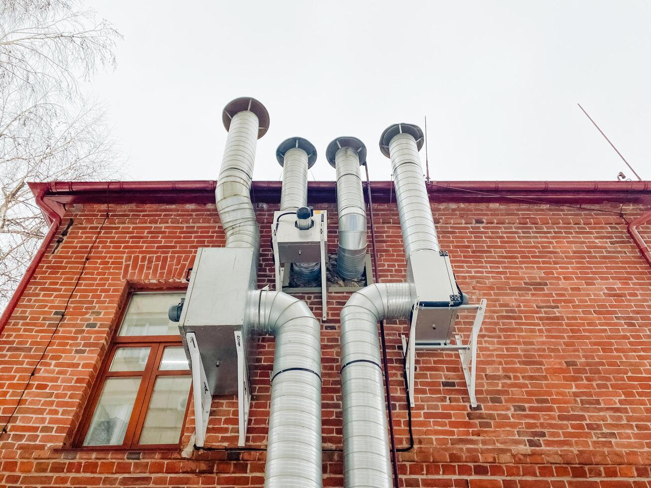 This sturdy brick structure features large pipes that showcase a wellintegrated plumbing and electrical system, delivering essential services conveniently throughout the building photo