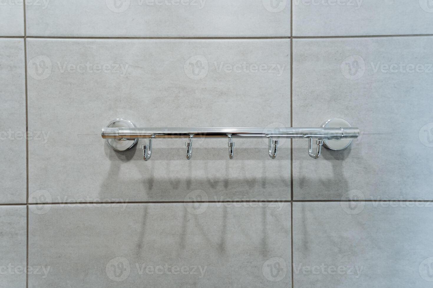 A towel rack is securely hanging on a beautifully tiled wall, adding both functionality and style to the space. It complements the overall aesthetic of the tiled interior design photo