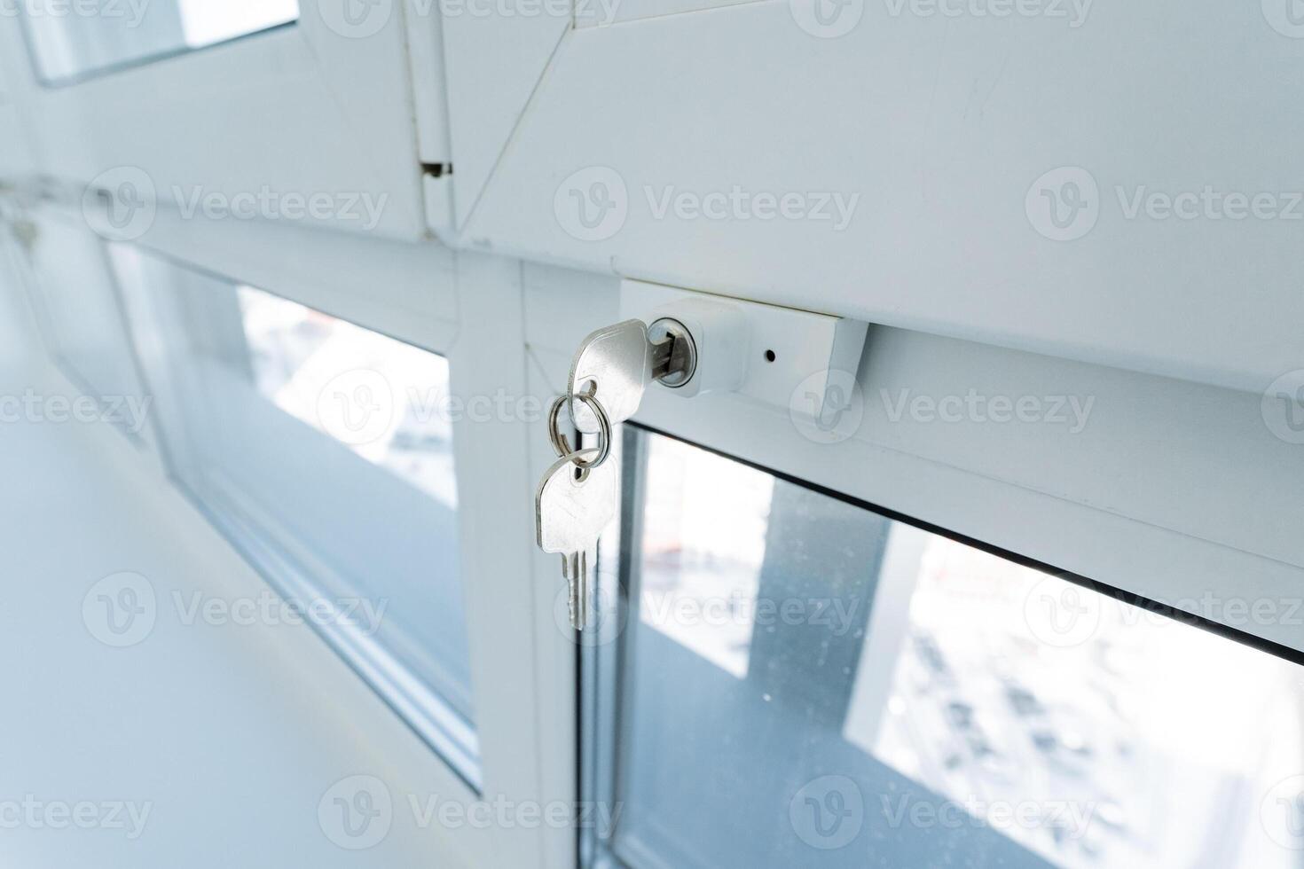 The image presents a closeup view of a window featuring a key inserted into the lock, hinting at various intriguing possibilities regarding entry points and overall security measures photo