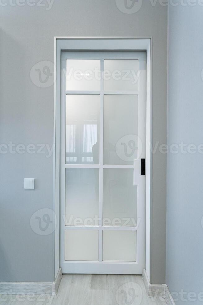 In a room, there is a white sliding glass door that features a sleek black handle. This door perfectly complements the overall interior design and aesthetics of the space photo