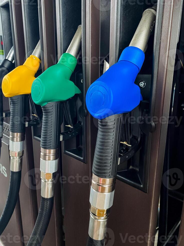 A long row of gas pumps featuring a variety of colored nozzles, each designated for different types of fuel and gasoline, commonly found in filling stations across the country photo