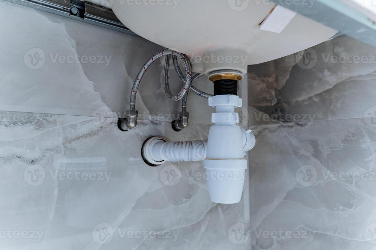 This is a sink that has a drain pipe securely attached to it, which ensures that water can flow properly away from the sink after it has been used for various activities photo
