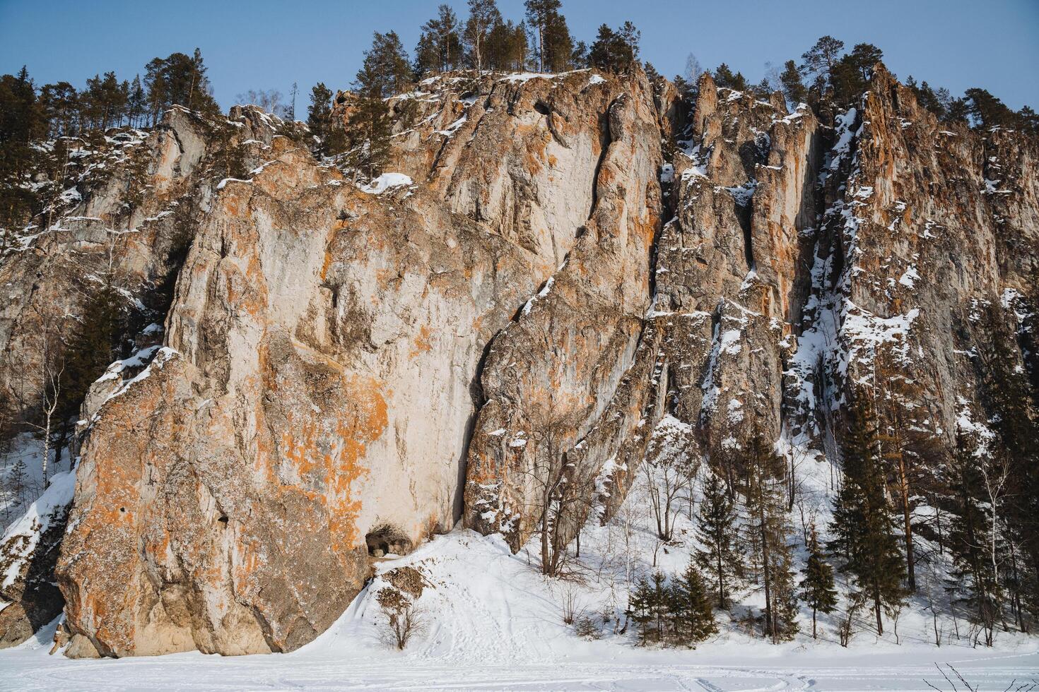 A magnificent snowy mountain that is predominantly covered in various rocks and lush green trees, creating a stunning and picturesque view of natures beauty and diversity in the wilderness photo