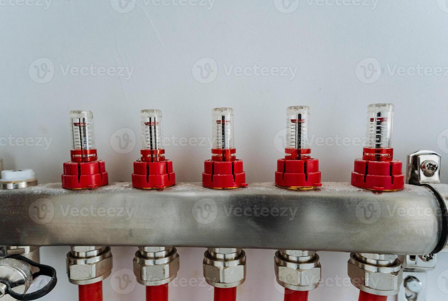 This image features a detailed close up of a stainless steel pipe that has bright red caps securely fitted on both ends, showcasing its industrial design and functionality photo