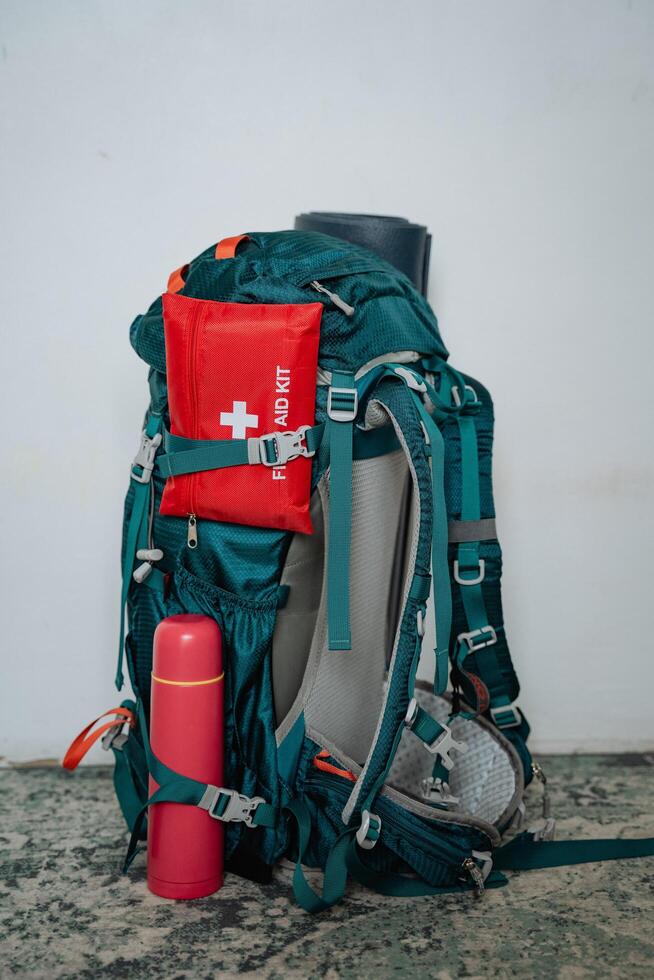 A sturdy backpack that comes equipped with a first aid kit and an insulated thermos attached to it, making it ideal for outdoor adventures and everyday carry necessities photo