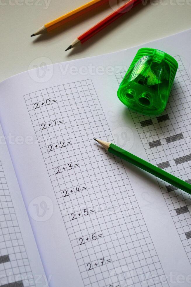 Learning to write letters correctly, notebook and pencils. Back to school photo
