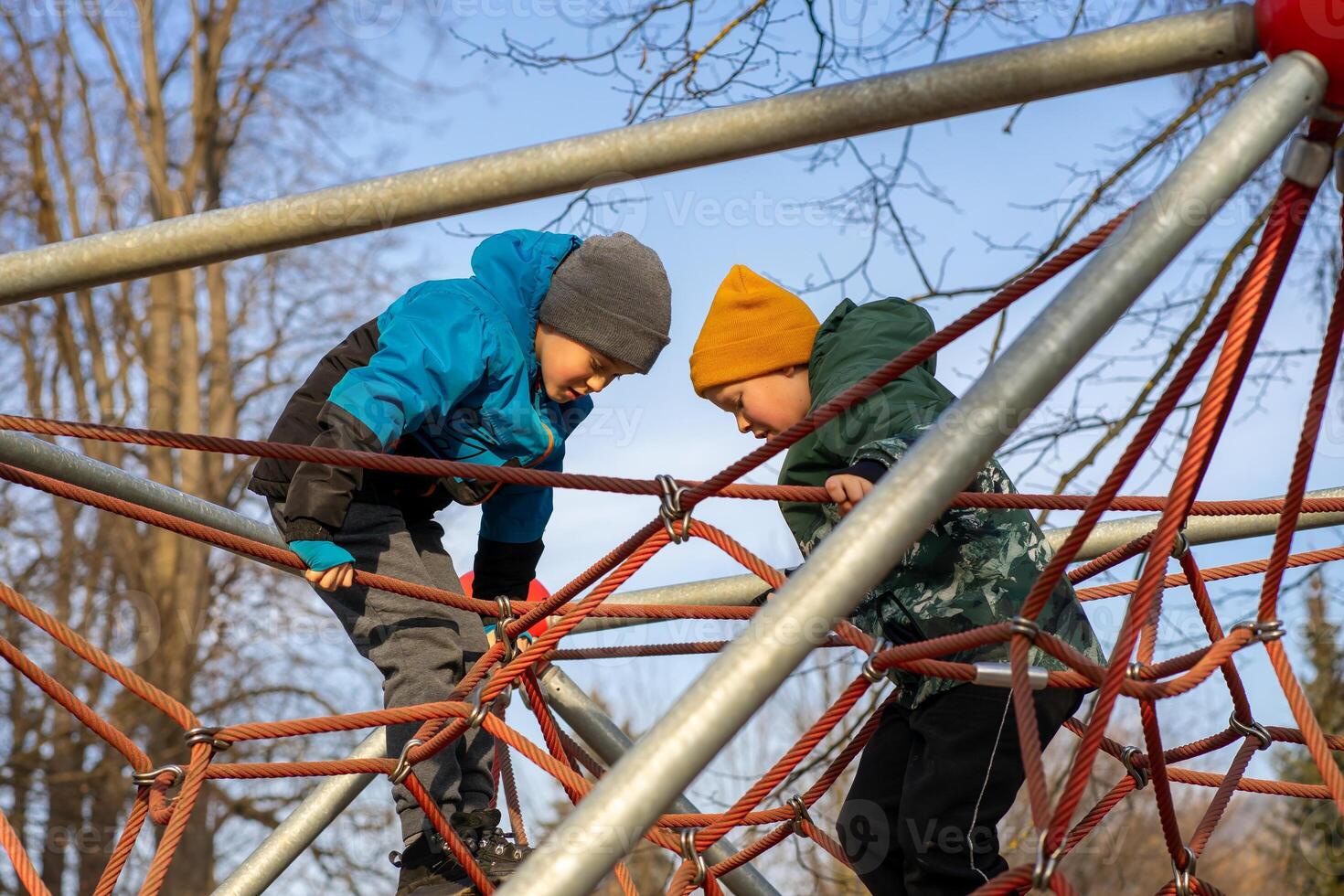 Two boys playing on the playground in the spring photo