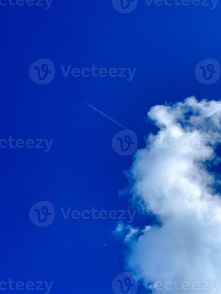 View of an airplane taking off from a white cloud against a blue sky photo