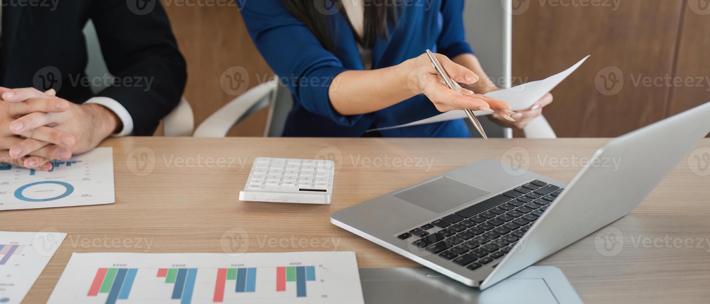 Close-up of businesswoman presenting financial reports to her team with professional tools and charts. photo