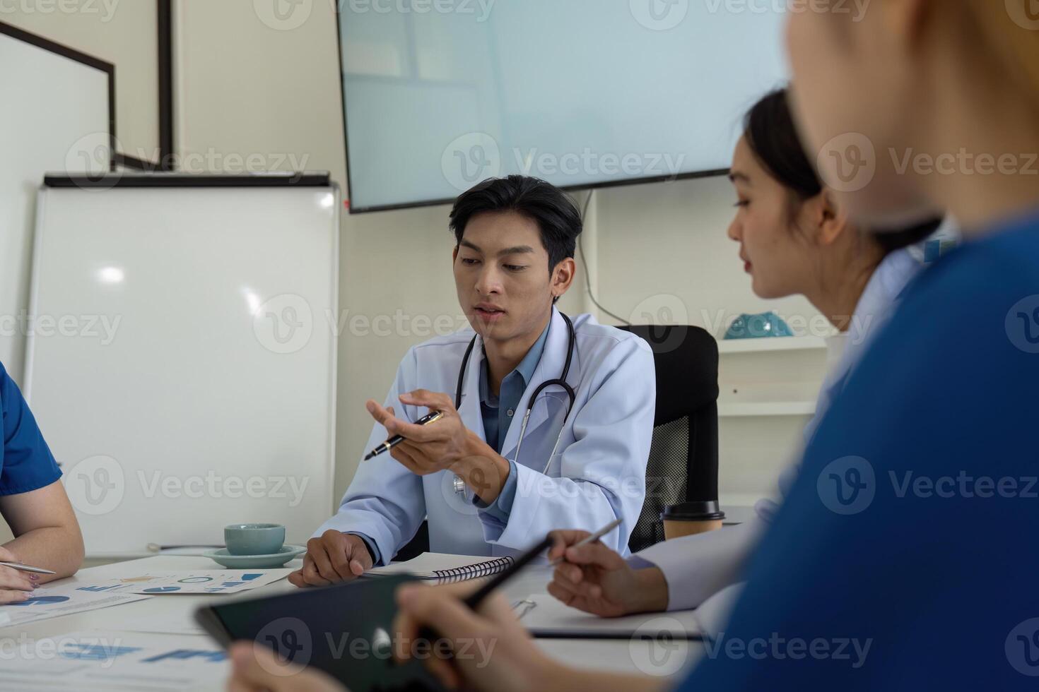Medical professionals in a meeting discussing patient analysis and healthcare strategies. photo