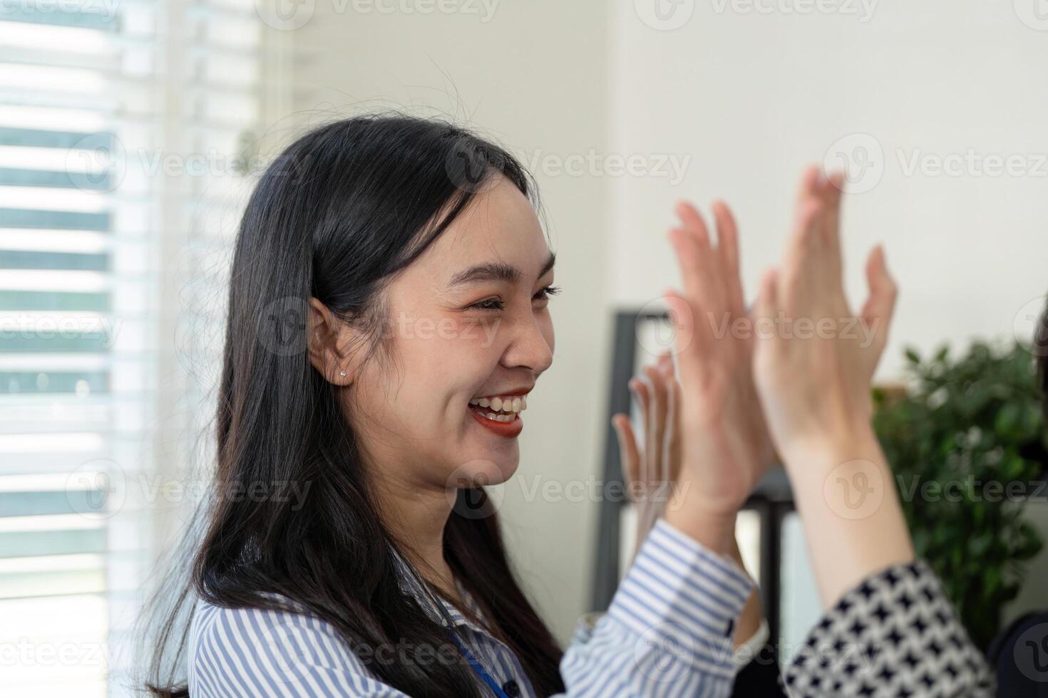 Joyful businesswoman celebrating with colleagues after a successful handshake, showcasing teamwork and positive relationships. photo