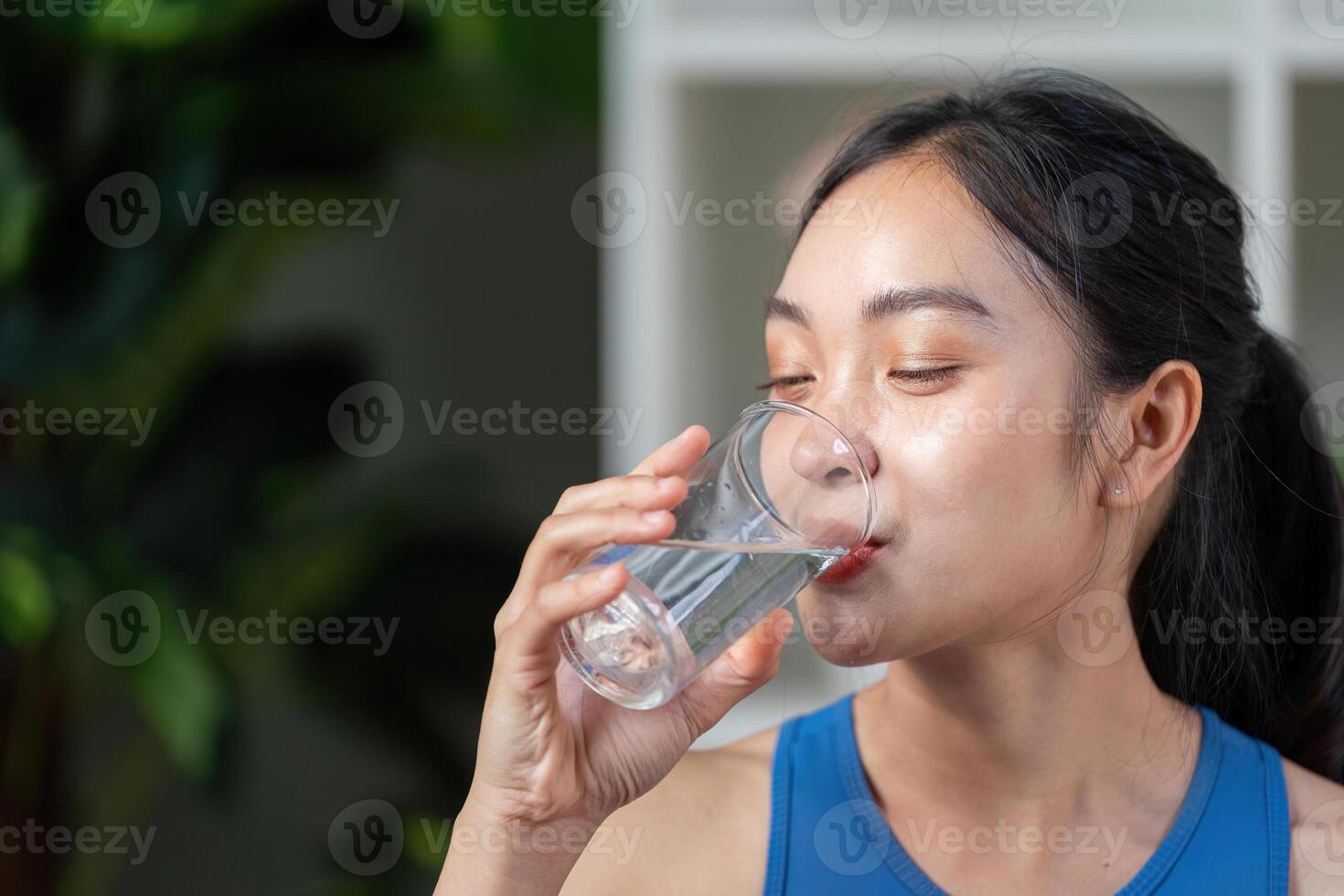 Active woman enjoying a refreshing drink, promoting hydration and wellness in a modern setting. photo