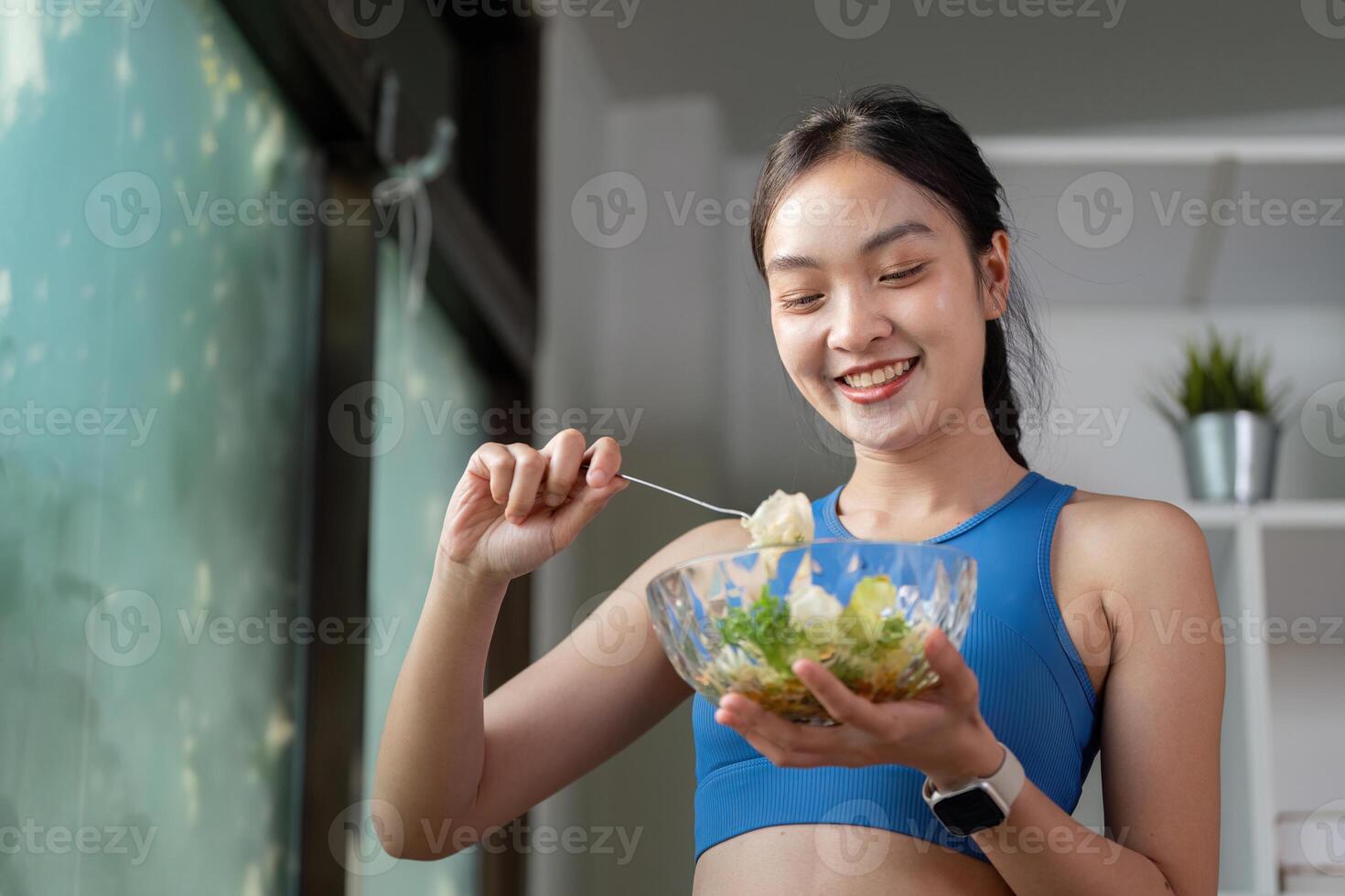 Smiling woman preparing a fresh salad, highlighting healthy eating and nutrition in a bright kitchen. photo