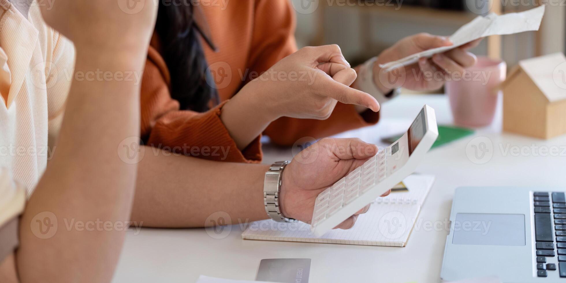 Couple discussing financial planning and managing bills with calculator and documents. photo