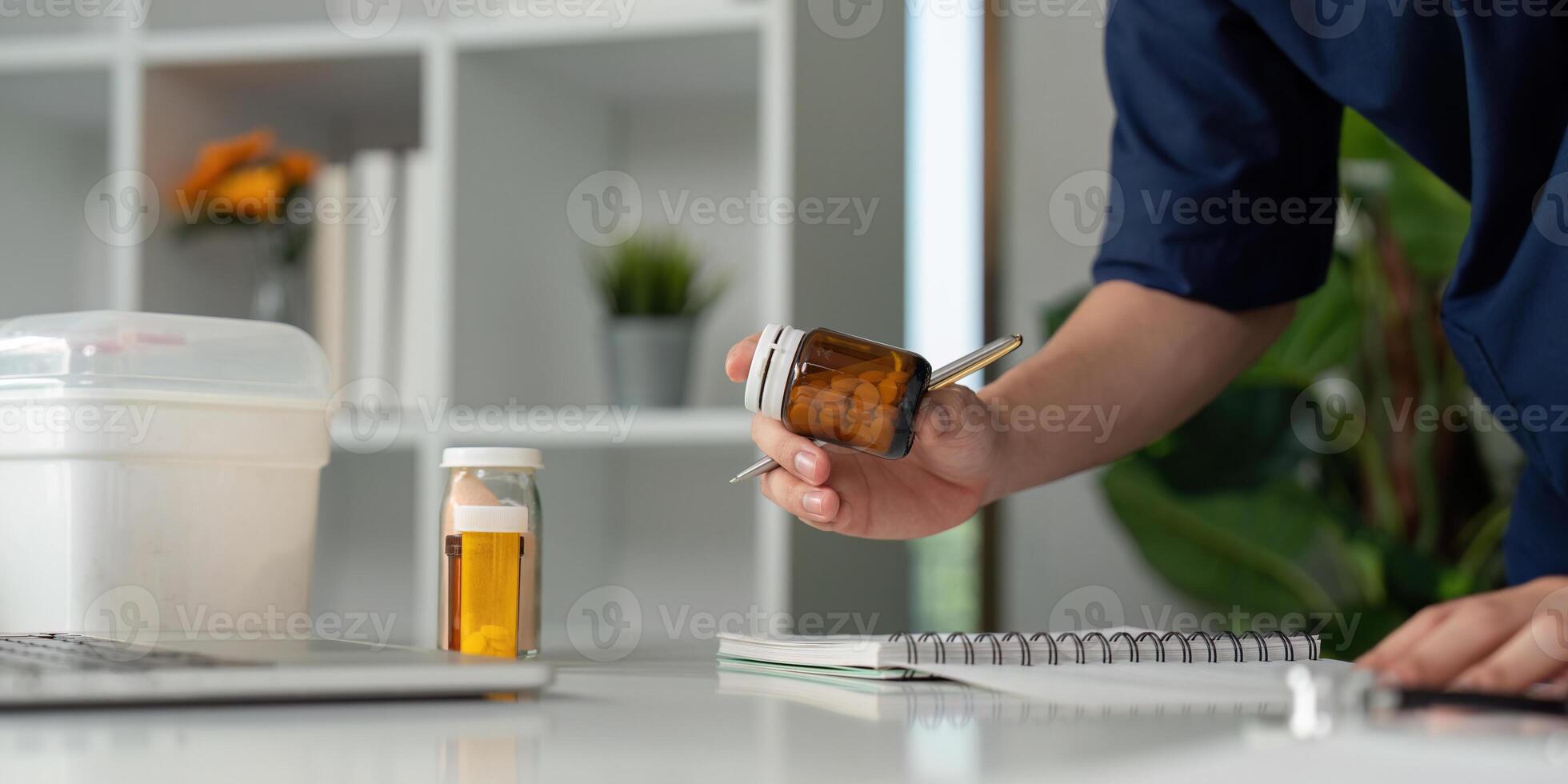 Medical student reviewing medication bottles and taking notes at a desk, focusing on patient care. photo