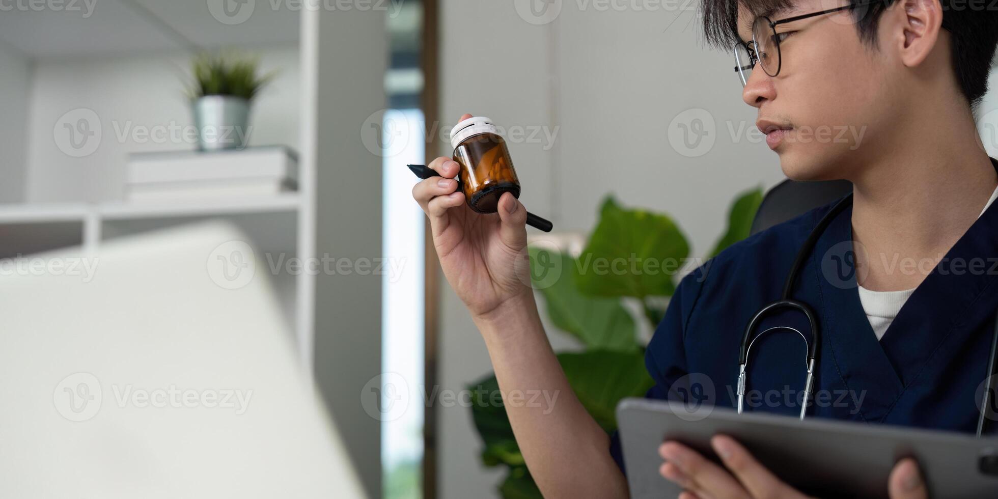 Medical student examining medication while taking notes in a contemporary office space. photo