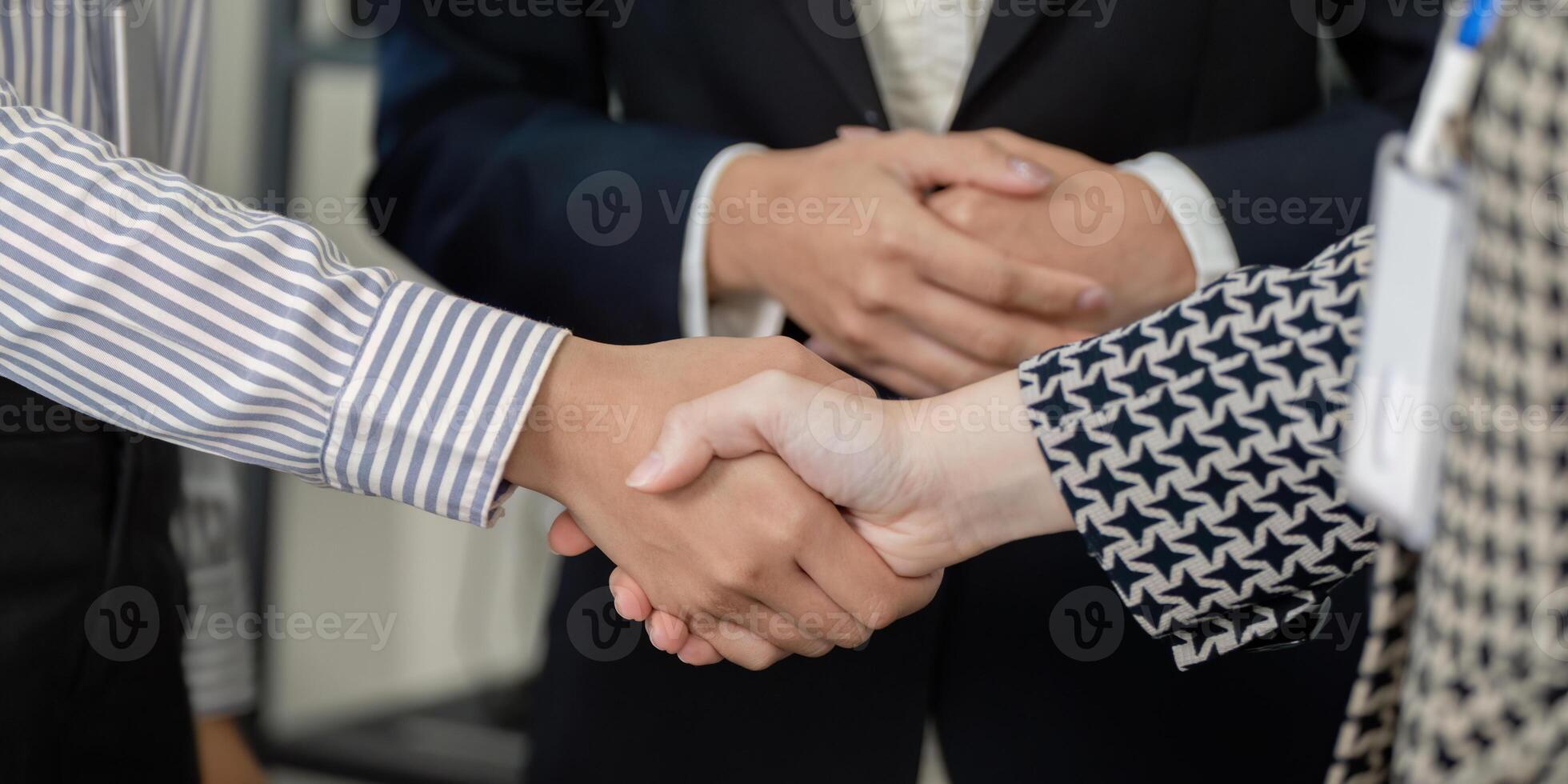 Diverse business professionals shaking hands to celebrate a successful partnership, showcasing teamwork and collaboration. photo