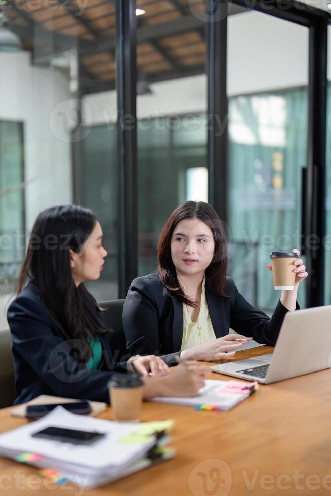 Professional women brainstorming project ideas and discussing strategies in a vibrant office environment. photo