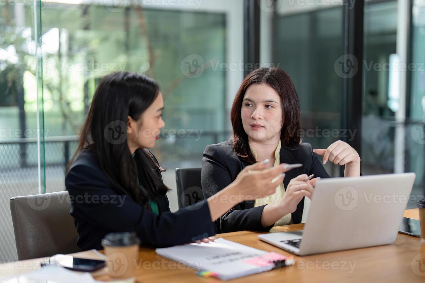 Engaged female colleagues reviewing project plans and collaborating on analysis in a contemporary office. photo