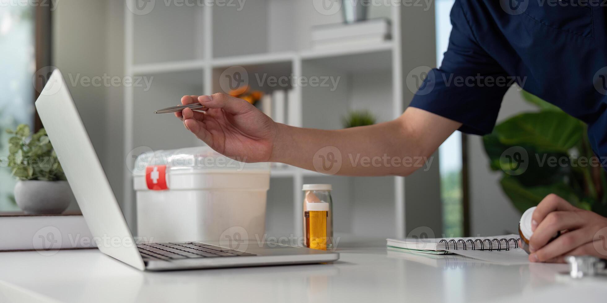 Medical student analyzing medication dosage while studying at a desk with a laptop and supplies. photo