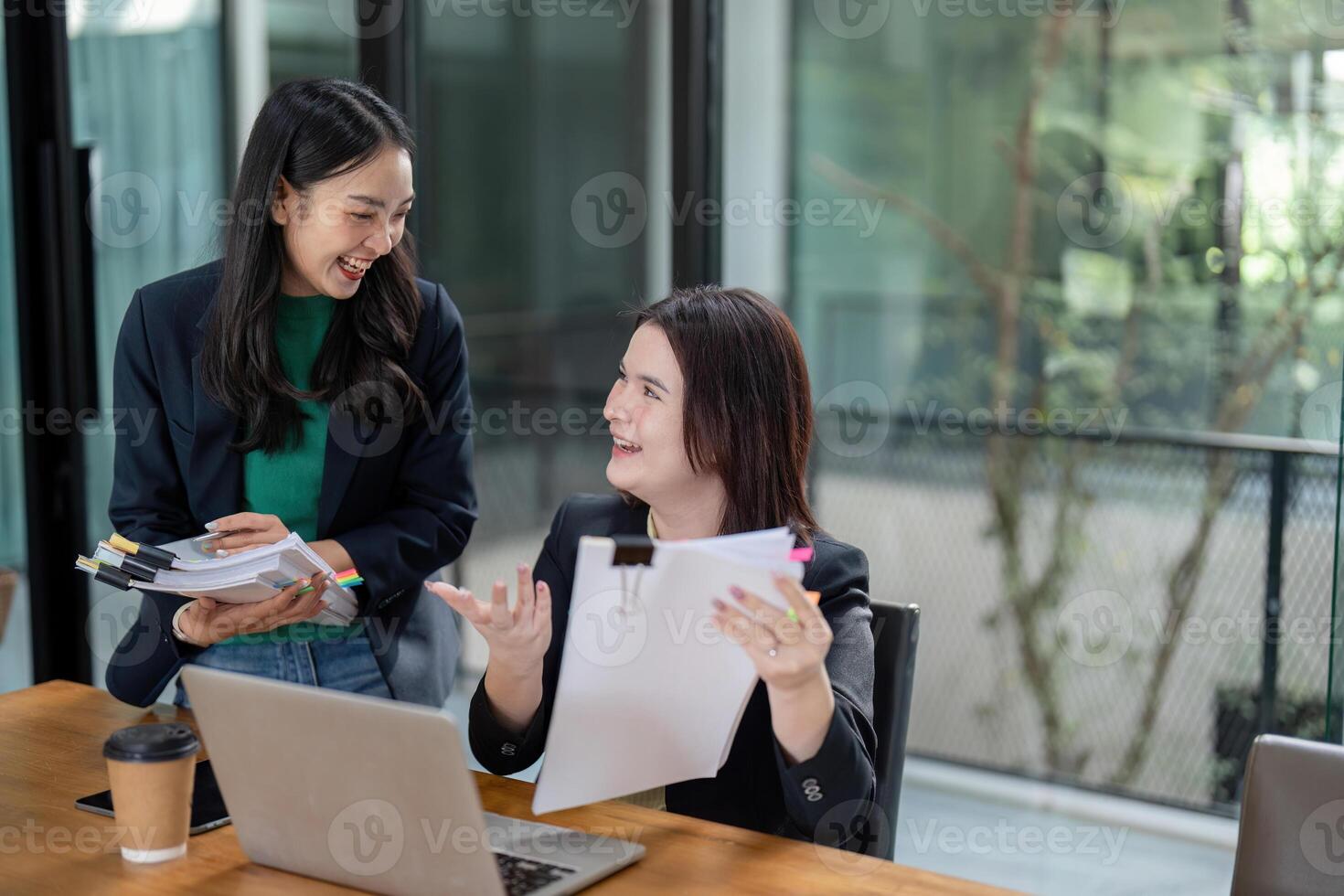 Diverse female team reviewing project progress and sharing insights in a modern collaborative workspace. photo