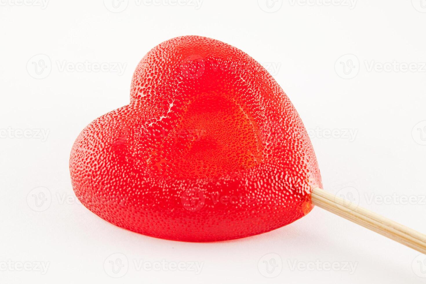 A red heart shaped lollipop on a stick photo