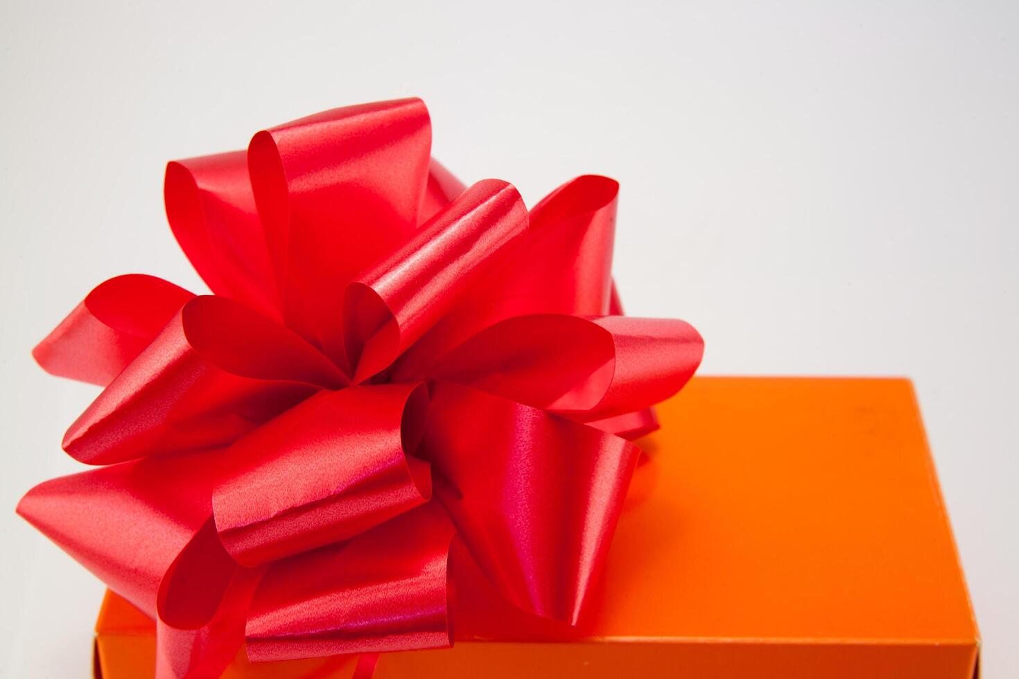 A red bow on an orange gift box photo