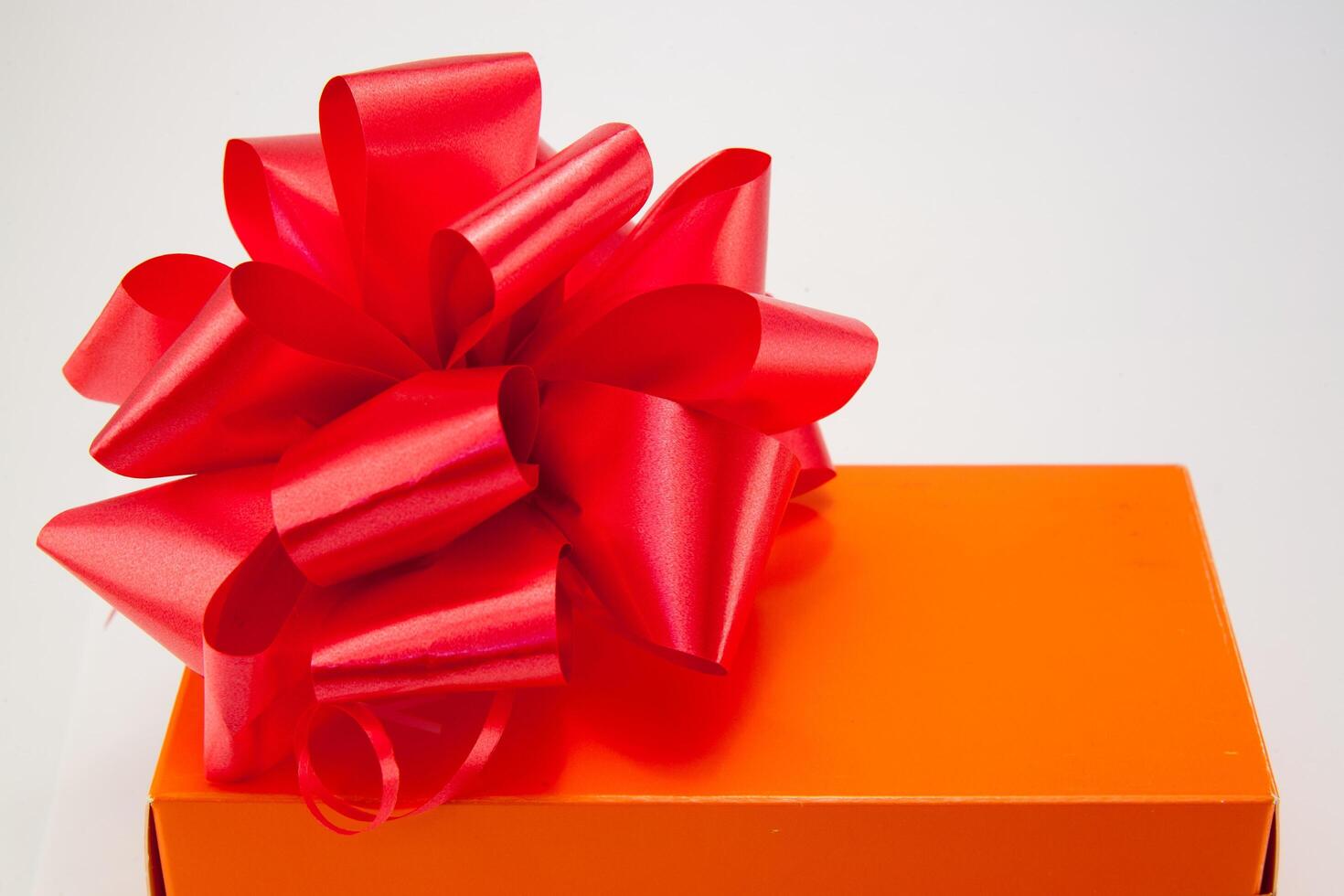 A red bow on an orange box photo