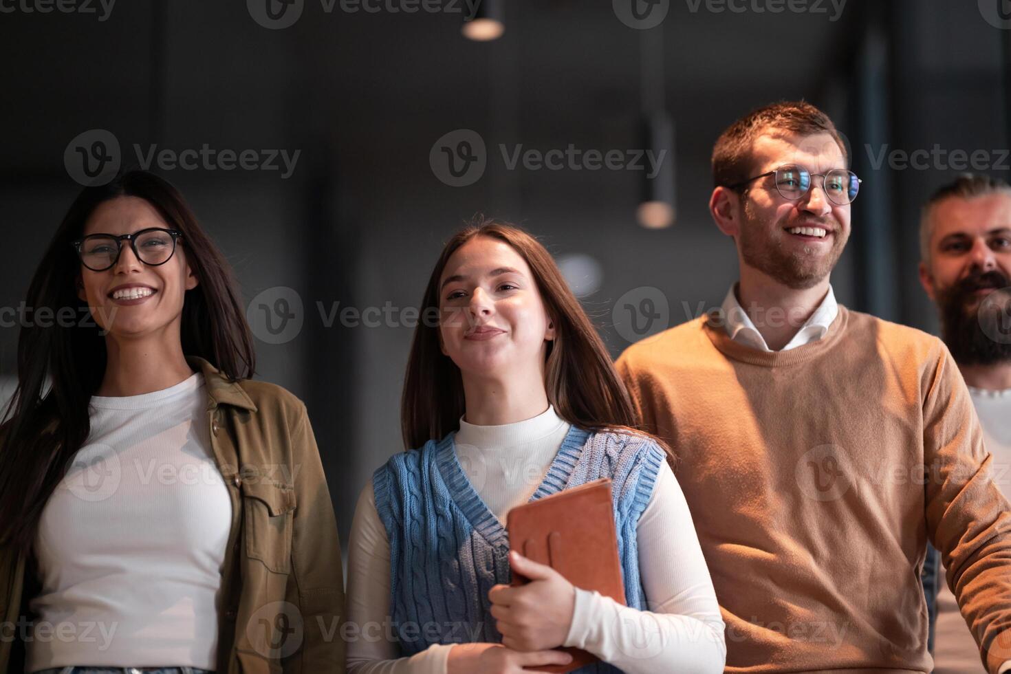 Business team in a modern open space startup office walking together. Diverse group of businesspeople smiling while having a discussion. Successful mixed race colleagues collaborating on a new project photo