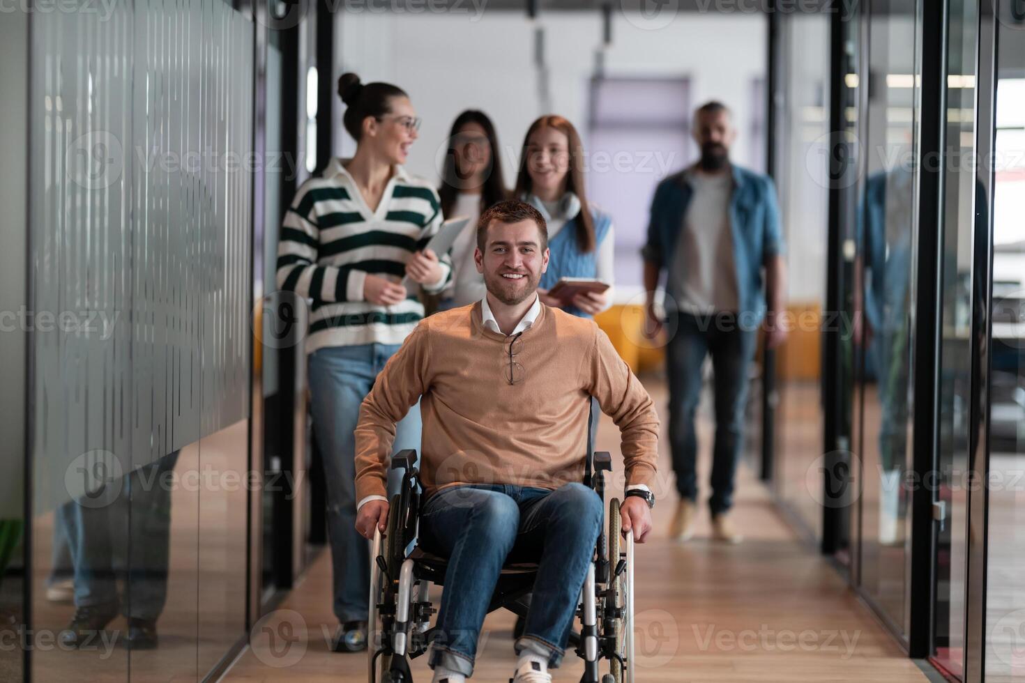 A businessman with disability in a wheelchair is surrounded by supportive colleagues in a modern office, showcasing the strength of teamwork, inclusivity, and empowerment in the face of challenges. photo