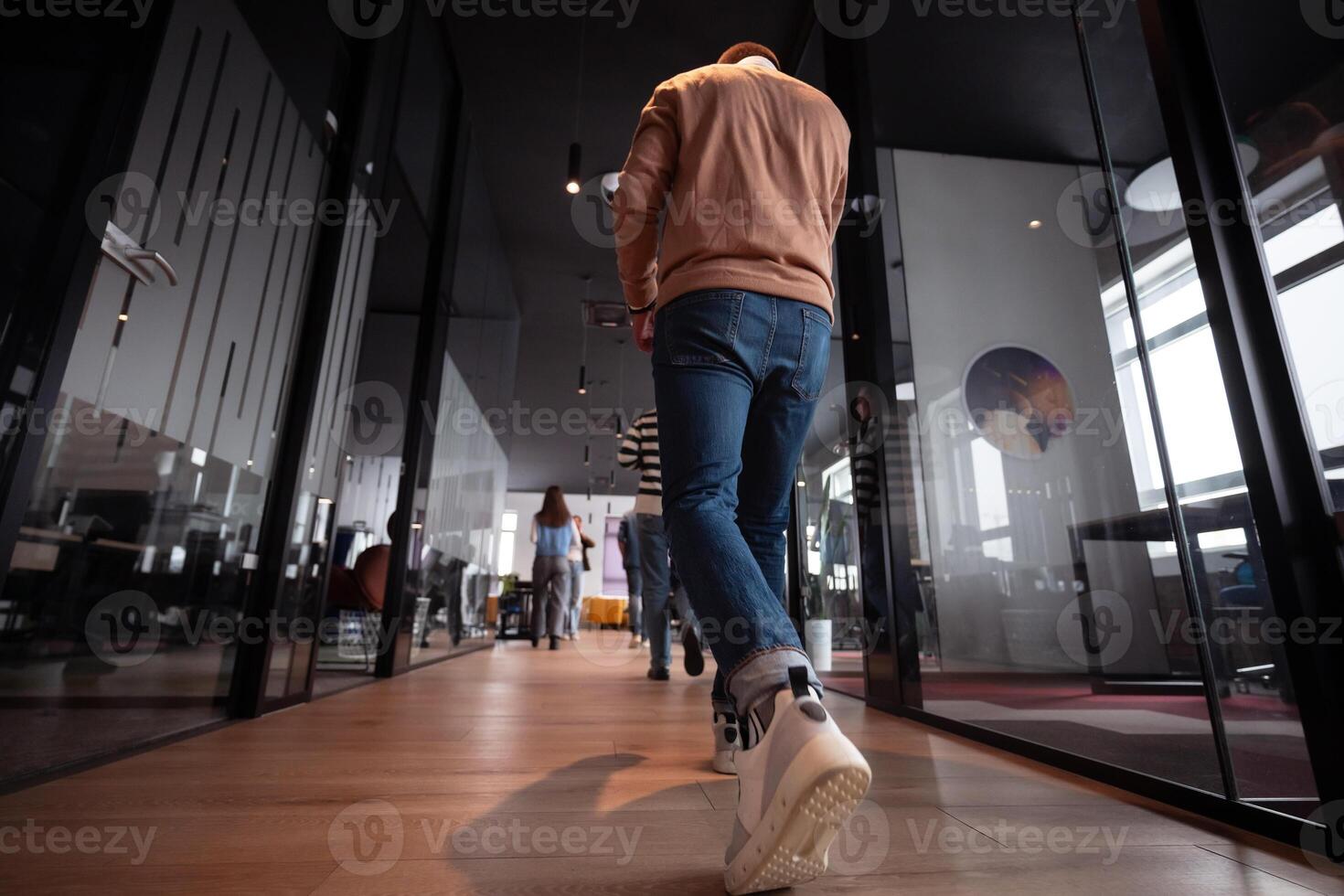 Business team in a modern open space startup office walking together. Diverse group of businesspeople smiling while having a discussion. Successful mixed race colleagues collaborating on a new project photo