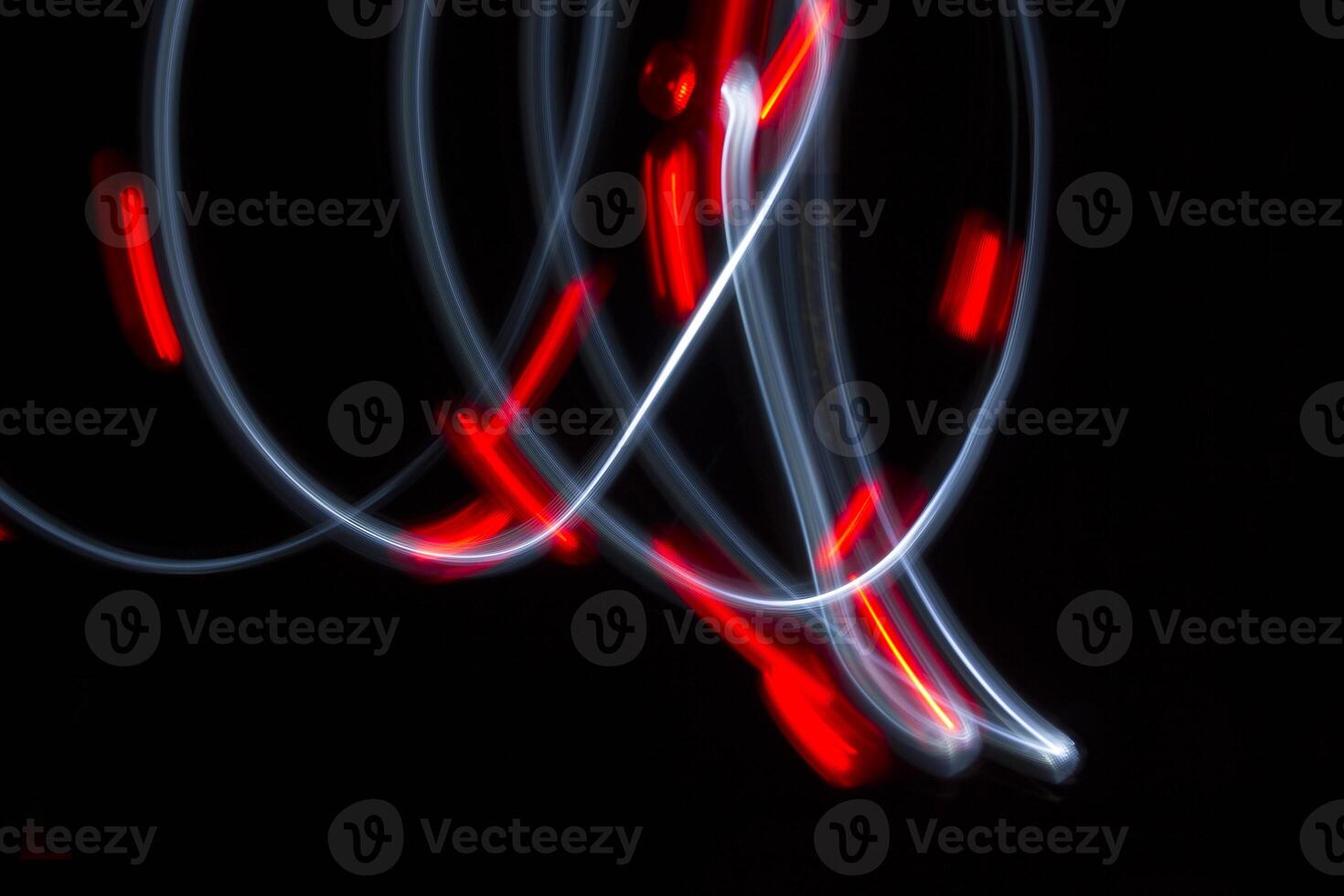 A photo with a long shutter speed of two lights moving. One light is white and one is red. The red one has flashed.
