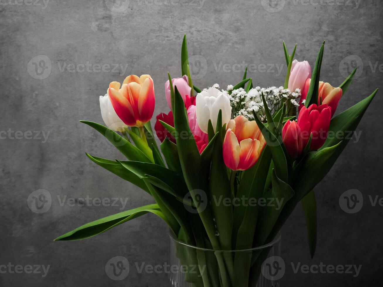 Vibrant bouquet of tulips adding a touch of color to a simple gray backdrop, celebrating the beauty of nature for Mother's Day Valentines copy space photo