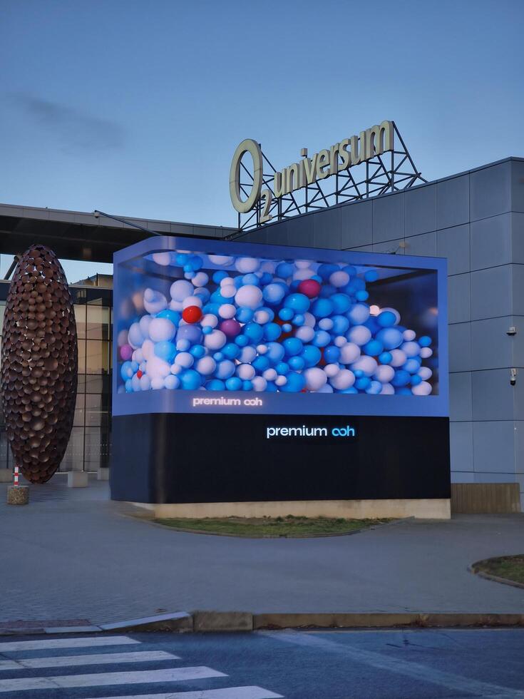 Prague, Czech republic - January 9, 2025 Large format transparent led screen showcasing an animation of colorful balloons at O2 universum Conference center Premium OOH photo