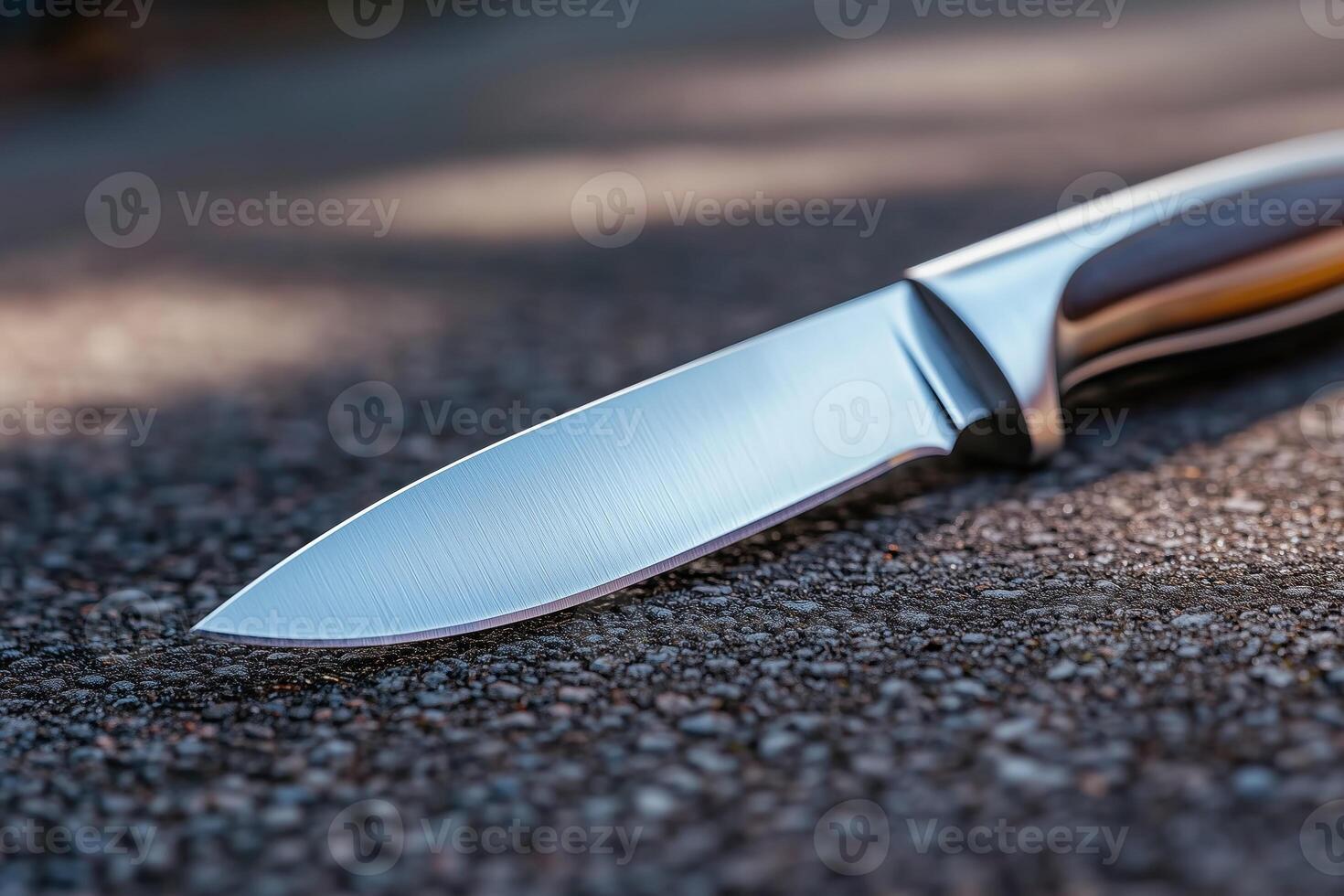Knife lies on the road close up. Selective focus. Shallow depth of field. photo