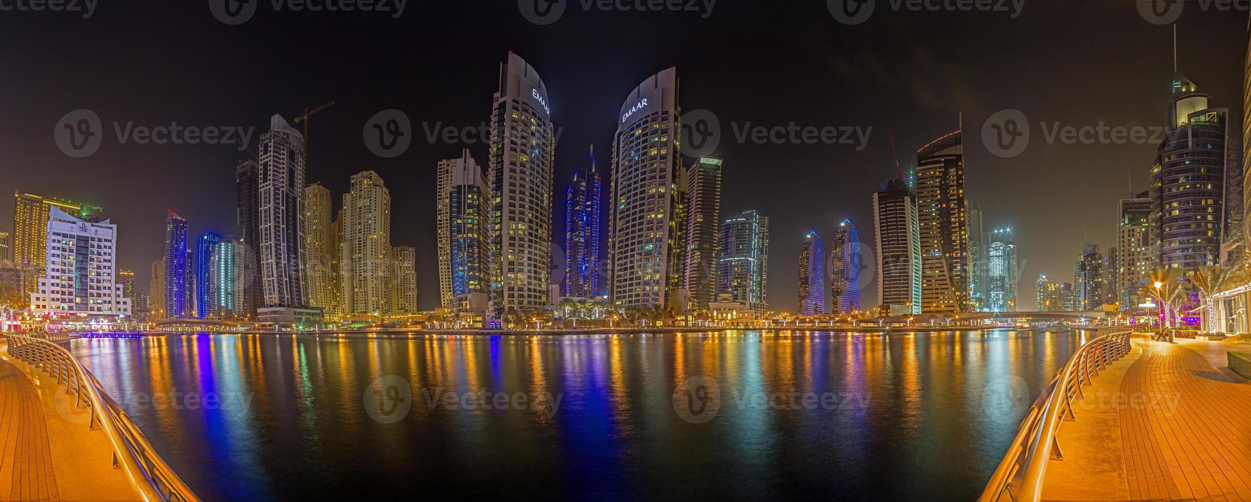Panoramic night view of Dubai Marina skyline with waterfront reflections f photo