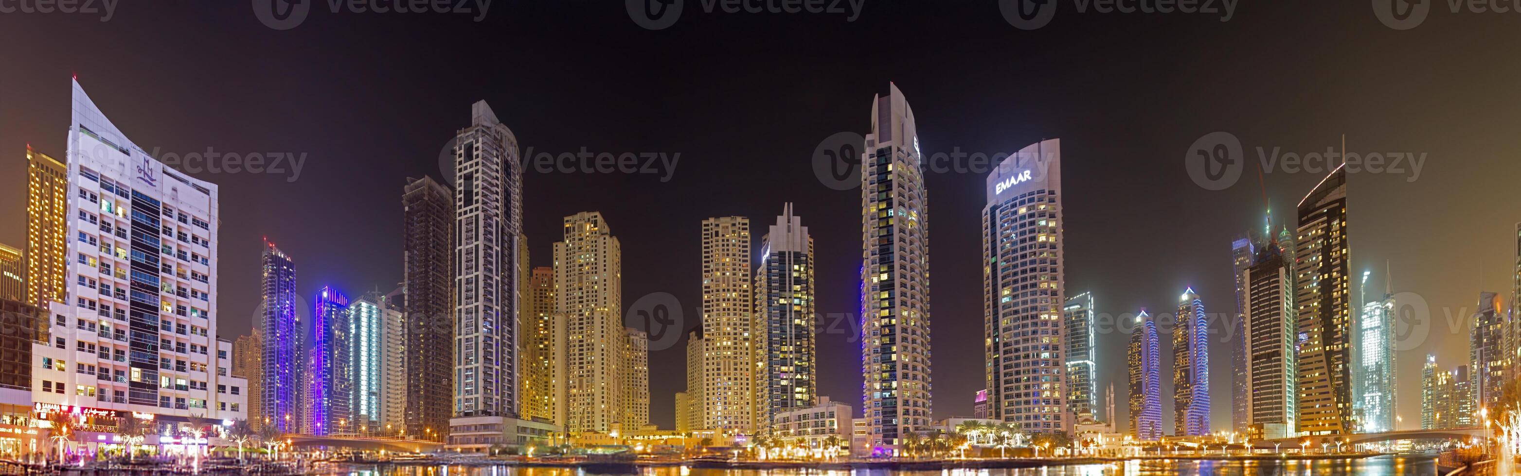 Panoramic night view of Dubai Marina skyline with waterfront reflections g photo