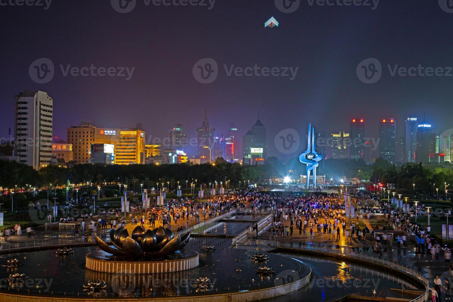 Illuminated fountain show at Quancheng Square in Jinan China with crowds at night b photo